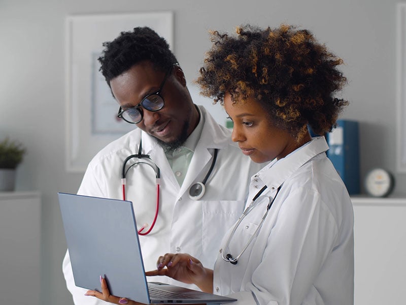 African-team-of-doctors-working-on-laptop-in-medical-office