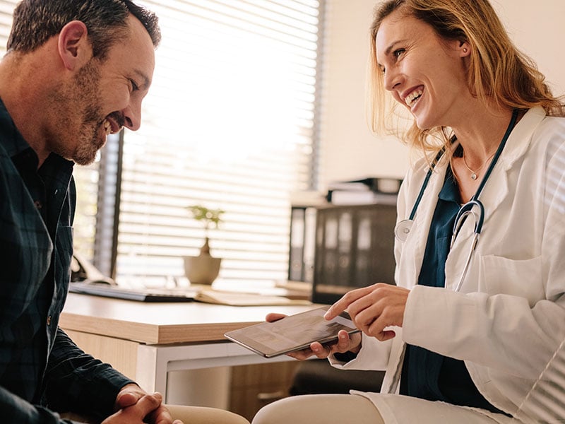 Female-doctor-showing-good-test-results-to-a-male-patient