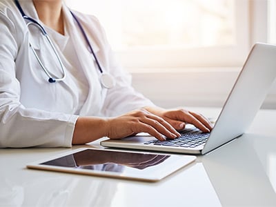 Female-doctor-typing-on-her-laptop-computer-in-medical-office