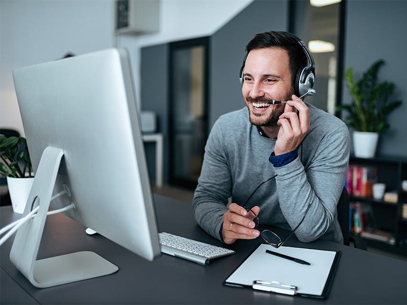 Happy-young-customer-support-operator-talking-to-his-satisfied-client